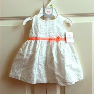 White eyelet dress with orange bow detail.